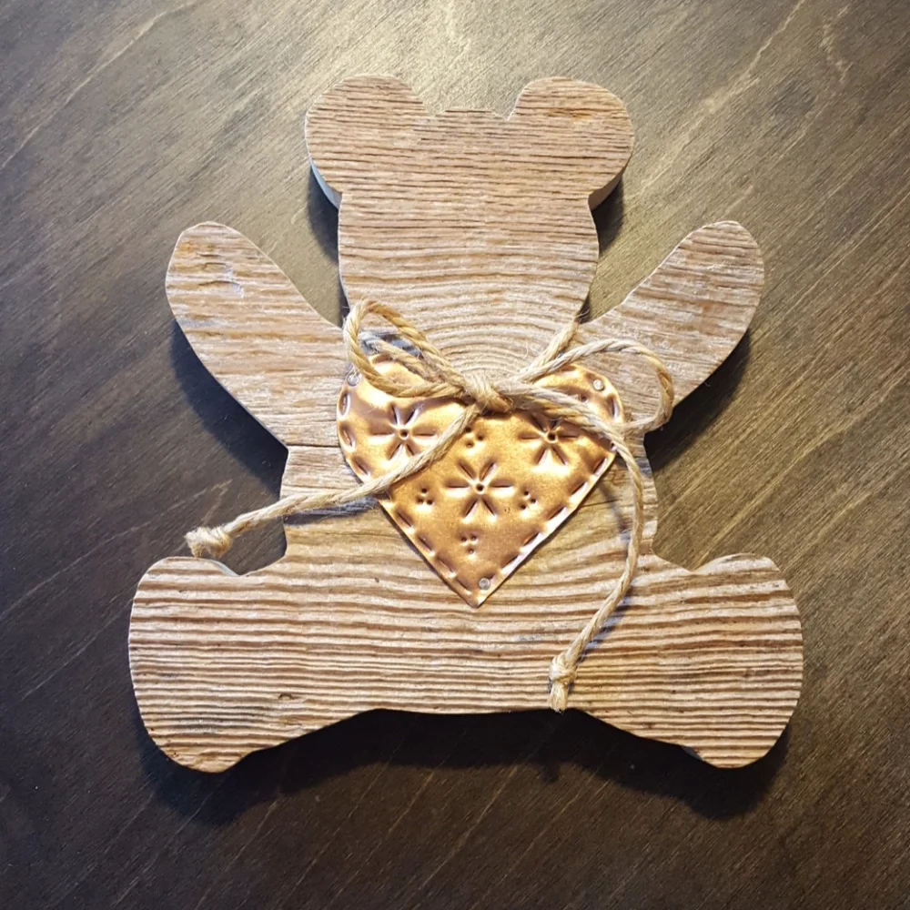 Wooden teddy bear cutout with copper heart.